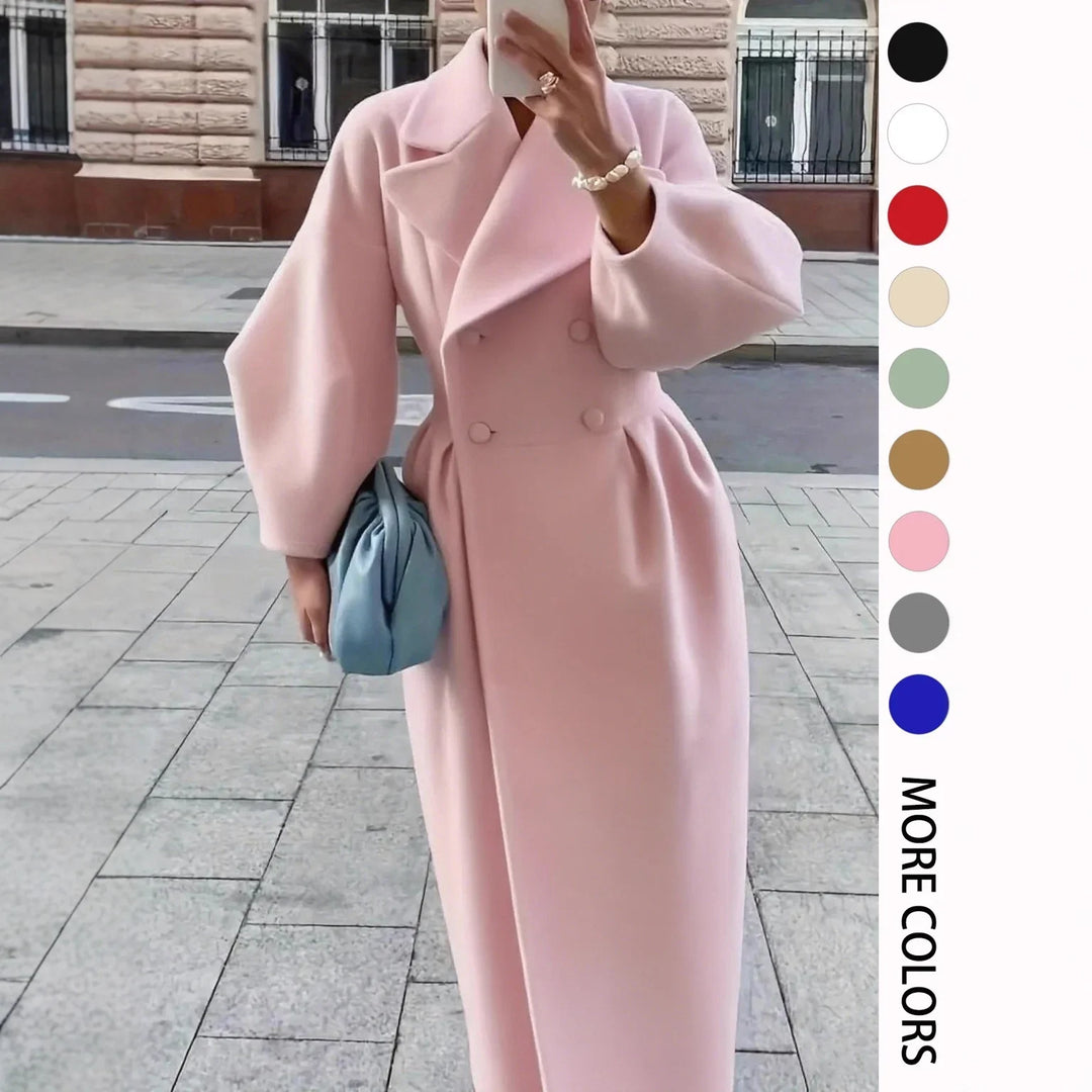 Woman wearing long pink double-breasted coat holding blue clutch purse on city sidewalk