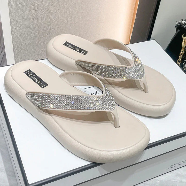 Beige flip-flop sandals with sparkling rhinestone straps, branded Helmazz, on white box