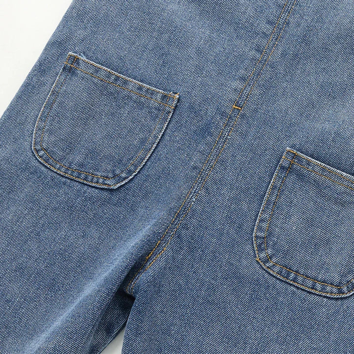 Close-up of blue denim jeans with two back pockets and detailed orange stitching
