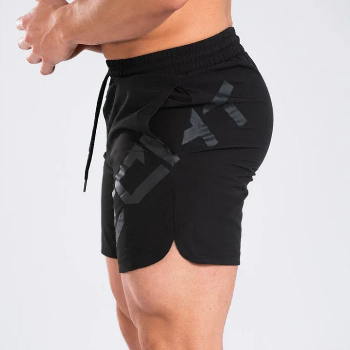 Side view of a man wearing black athletic gym shorts with drawstring and bold logo print