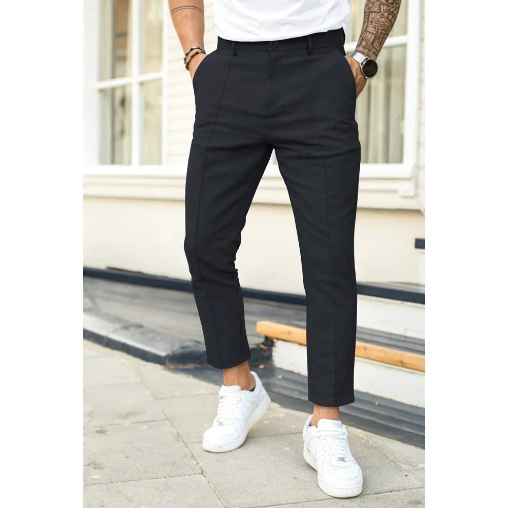 Man wearing black slim-fit dress pants with white sneakers standing outdoors