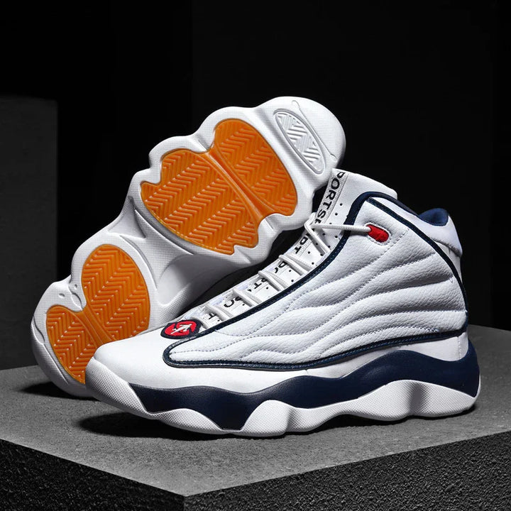 White and navy high-top basketball sneakers with orange textured soles on a dark surface