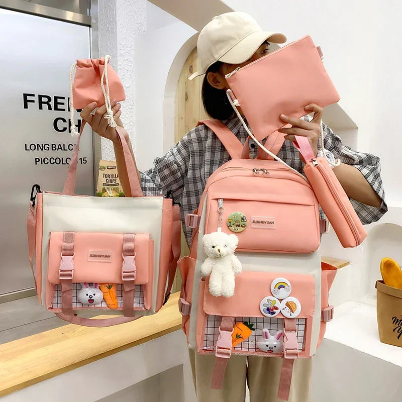 Person holding pink and white backpacks and pouches with cute cartoon patches and teddy bear keychain