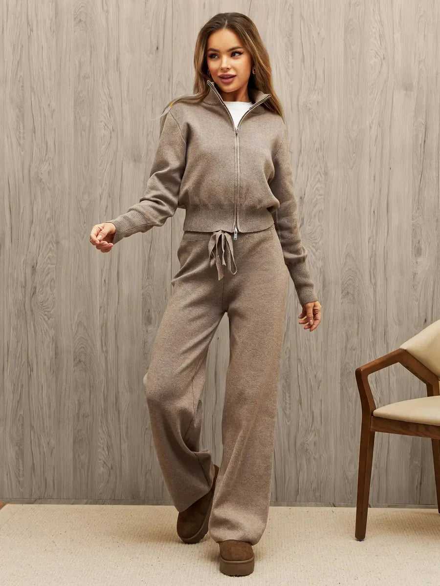 Woman wearing beige knitted zip-up sweater and wide-leg pants with drawstring, posing indoors