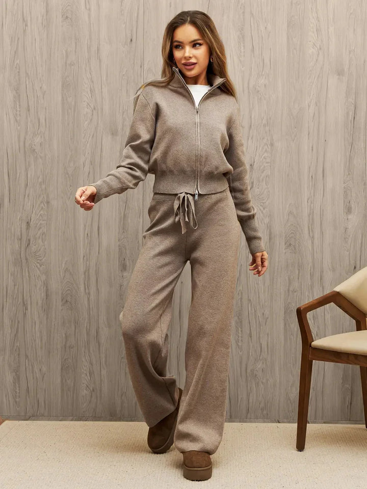 Woman wearing beige knitted zip-up sweater and wide-leg pants with drawstring, posing indoors