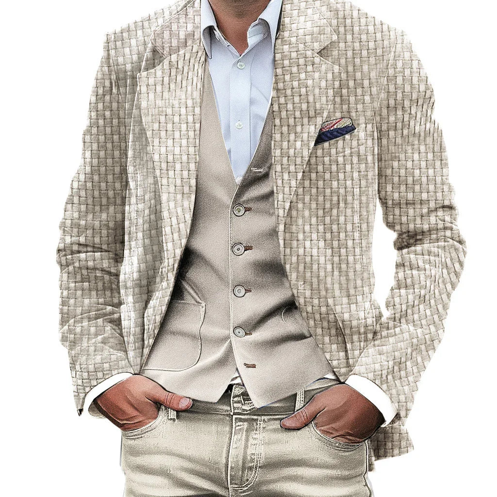 Man wearing beige textured blazer, light tan vest, white shirt, and light-colored jeans with hands in pockets
