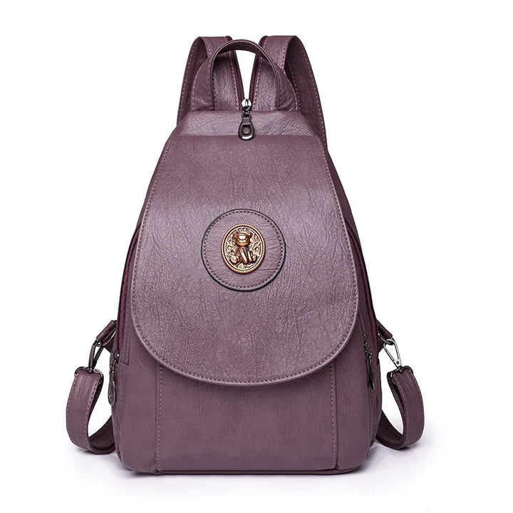 Purple faux leather backpack with gold teddy bear emblem and adjustable straps