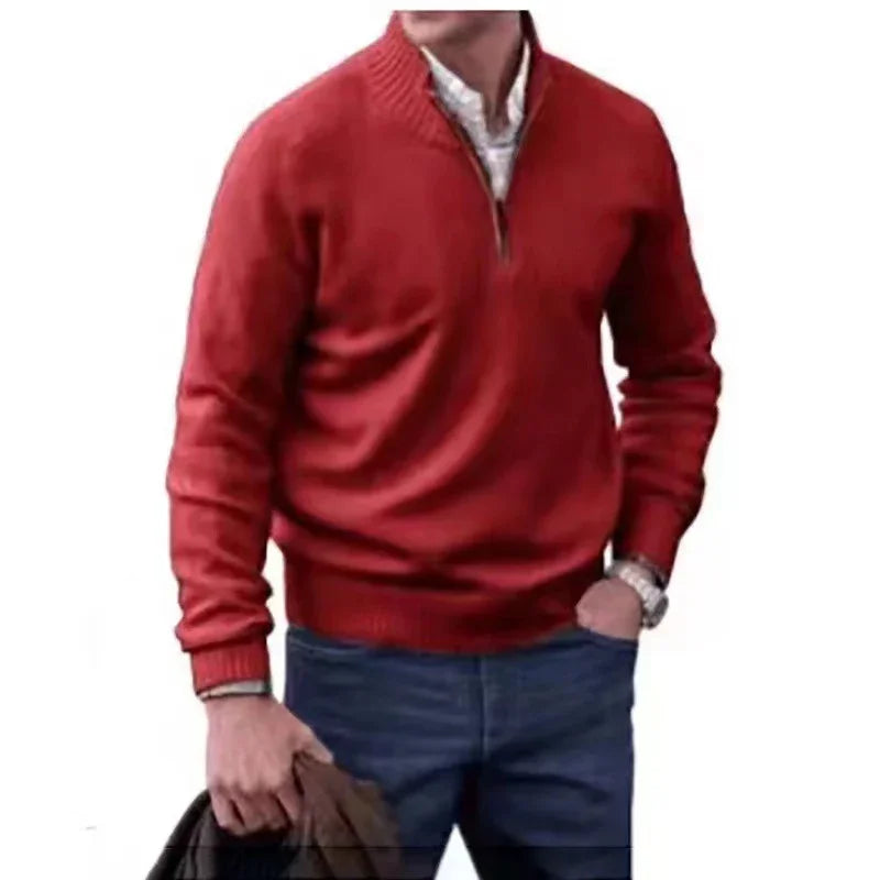 Man wearing red half-zip sweater, white shirt, blue jeans, holding brown jacket