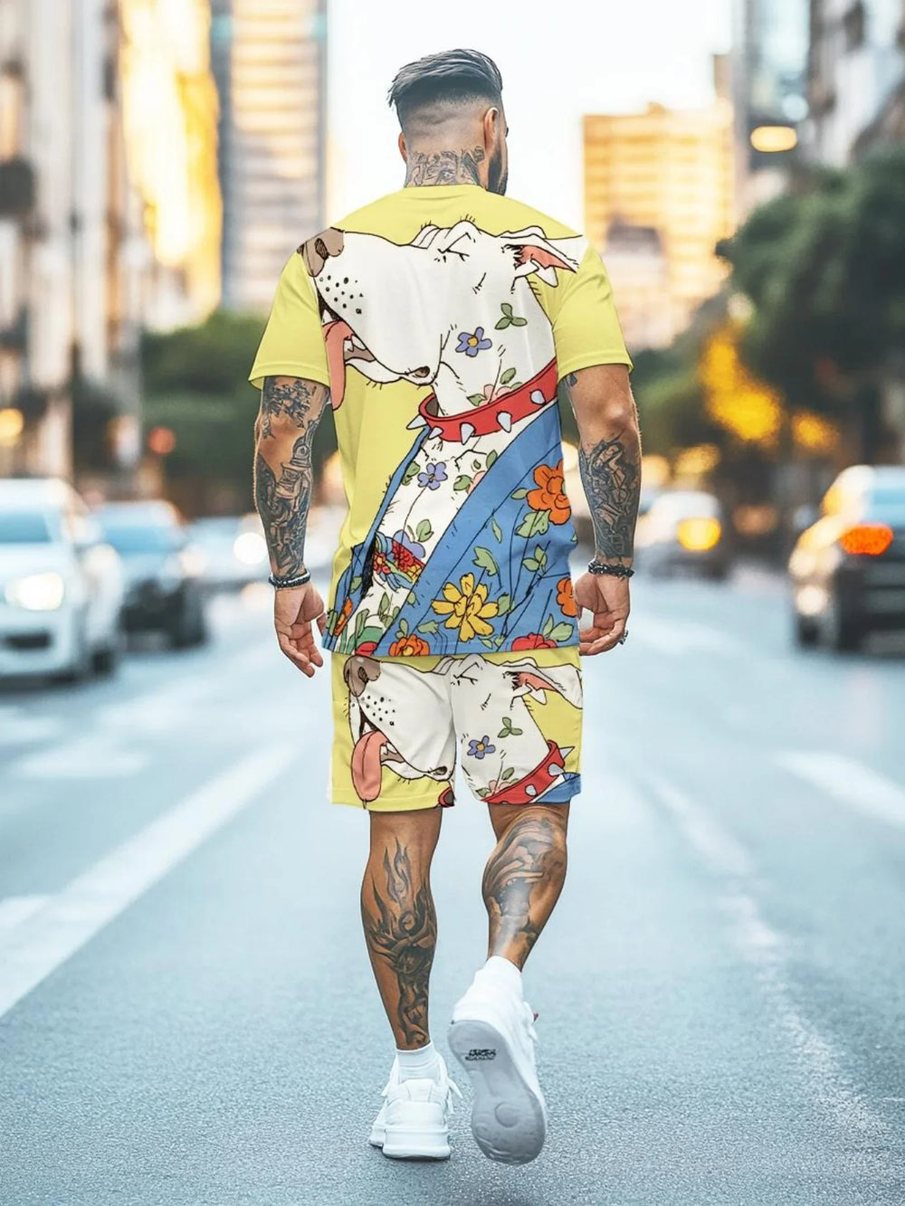 Man with tattoos wearing yellow matching T-shirt and shorts set featuring a large cartoon dog and floral print, walking on city street