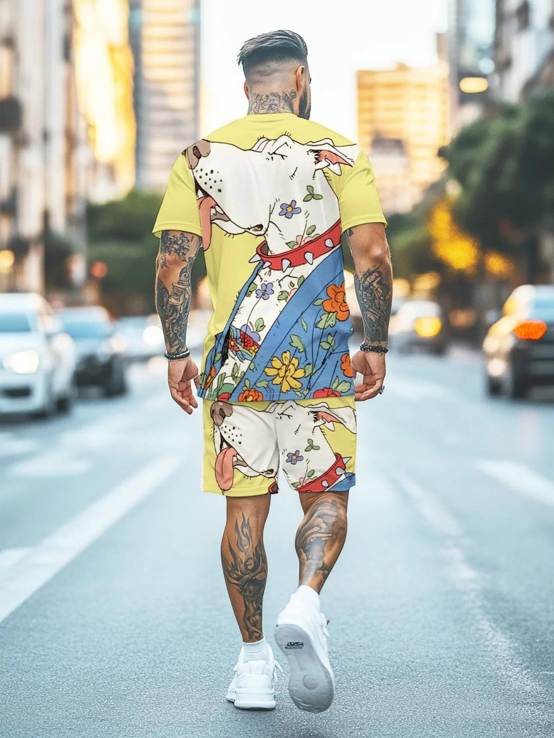 Man with tattoos wearing yellow matching T-shirt and shorts set featuring a large cartoon dog and floral print, walking on city street
