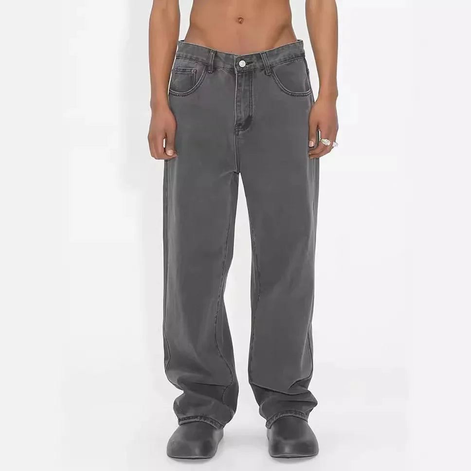 Front view of person wearing loose fit faded black jeans and black shoes on white background