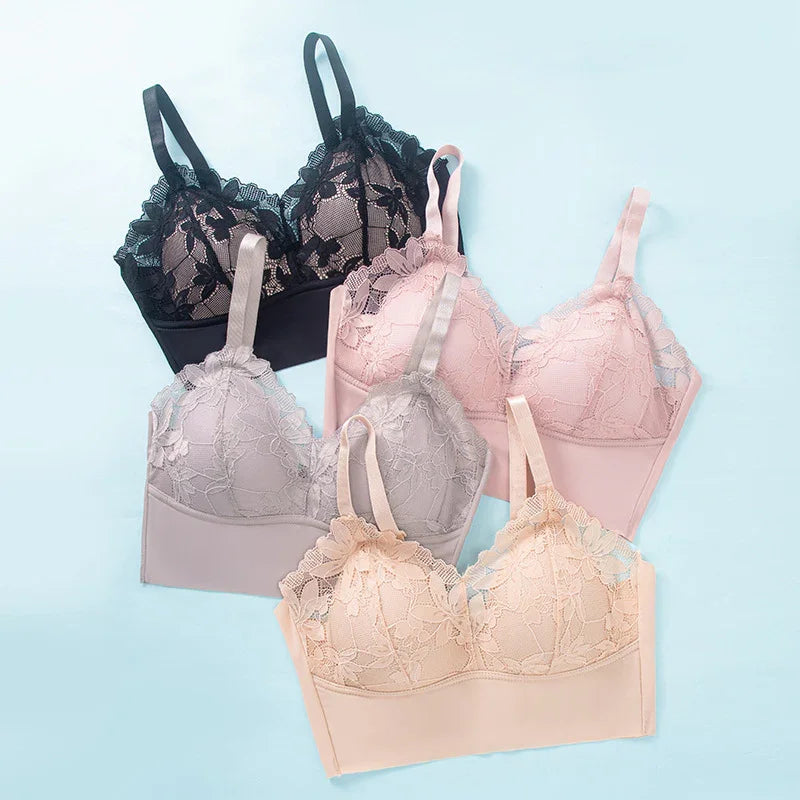 Set of four lace bras in black, pink, gray, and beige on light blue background