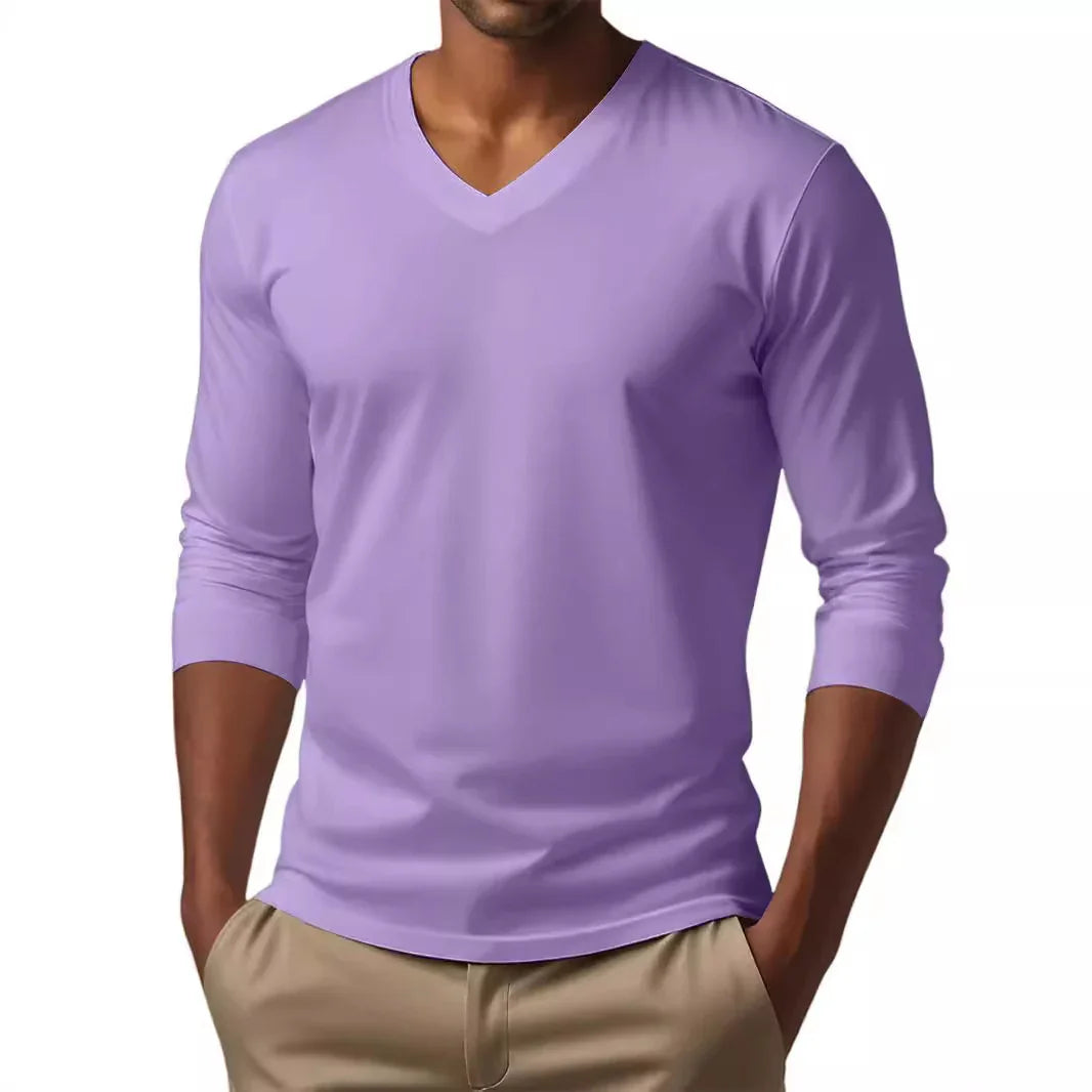 Man wearing a lavender long-sleeve V-neck shirt with beige pants, hands in pockets