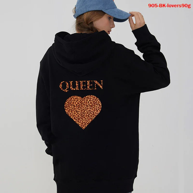 Woman in black hoodie with leopard print heart and 'QUEEN' text on back, wearing blue cap