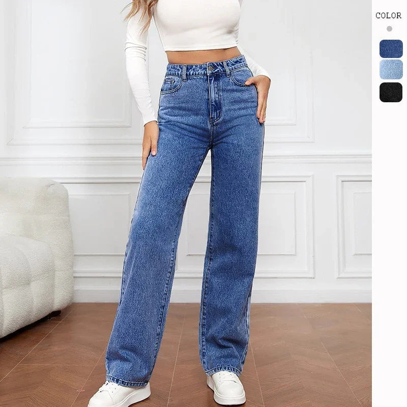 Woman wearing high-waisted blue wide-leg jeans with white crop top and sneakers indoors