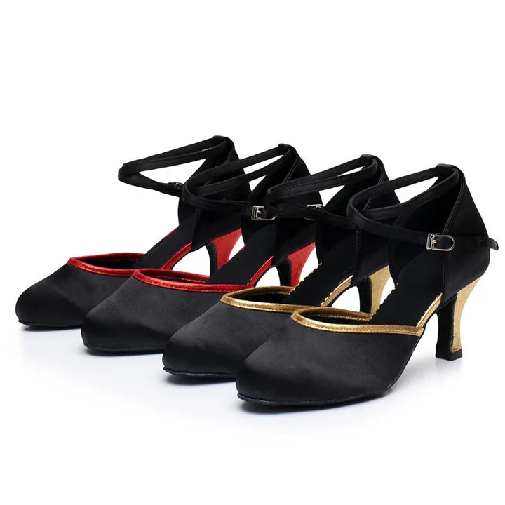 Black satin dance shoes with ankle straps, featuring red and gold trim and matching colored heels