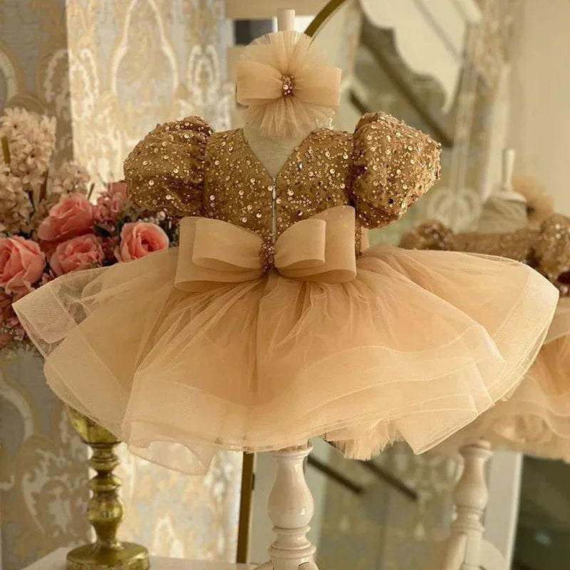 Elegant gold sequin toddler dress with puff sleeves and tulle skirt on mannequin