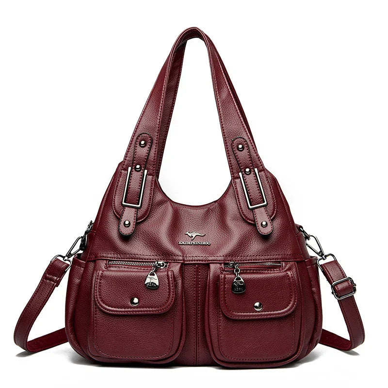 Burgundy leather handbag with dual top handles, detachable shoulder strap, front zippered pockets, and silver-tone hardware