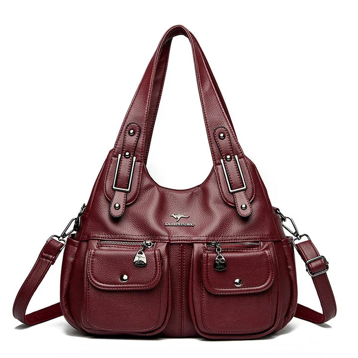 Burgundy leather handbag with dual top handles, detachable shoulder strap, front zippered pockets, and silver-tone hardware