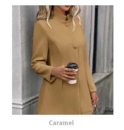Woman wearing caramel-colored buttoned coat holding coffee cup in urban setting