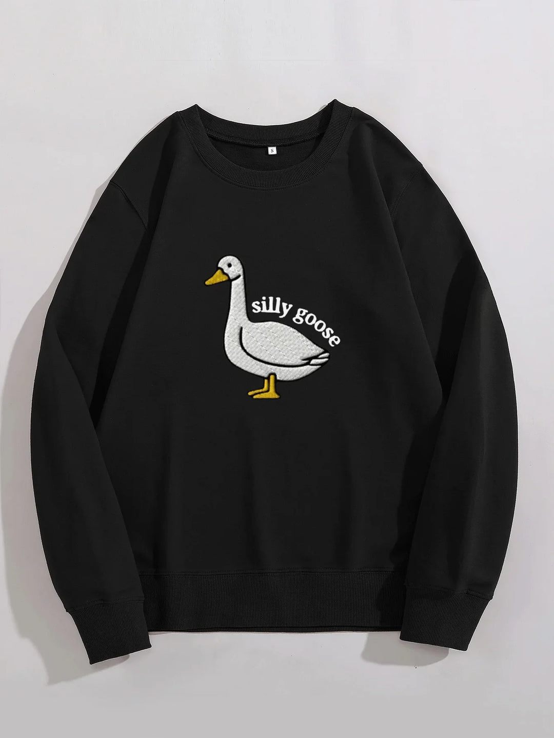 Black sweatshirt with white goose graphic and text 'silly goose' embroidered on front