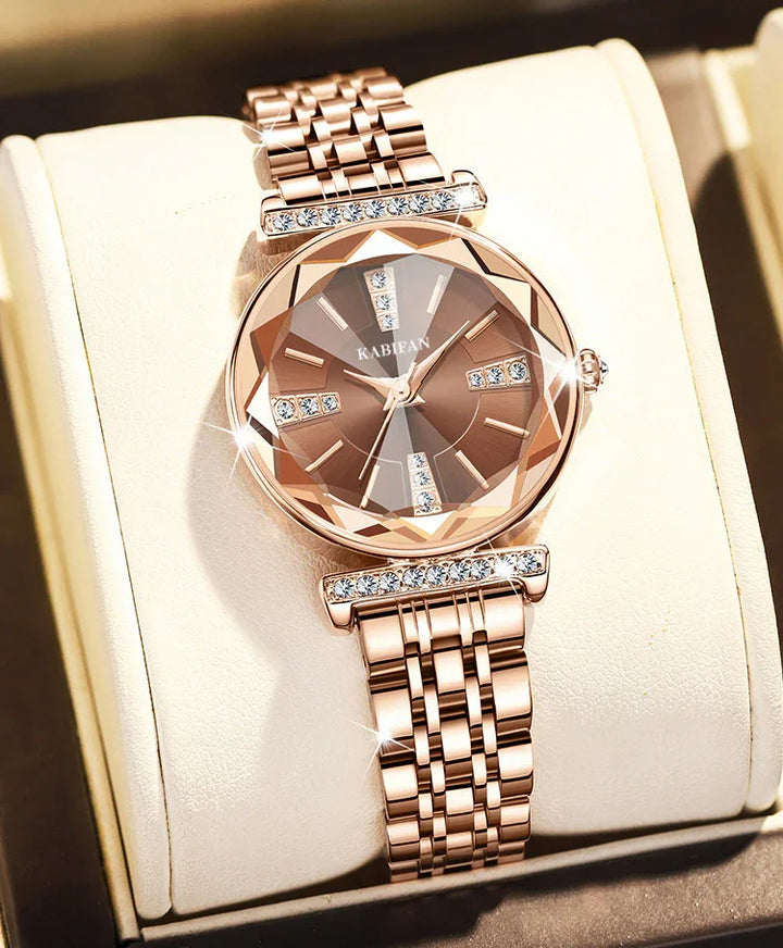Rose gold women's wristwatch with crystal-accented dial and bracelet on a beige cushion