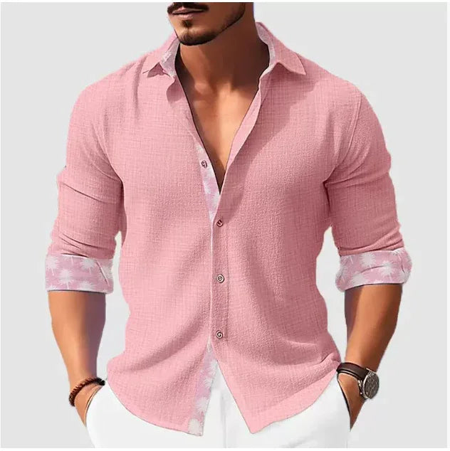 man wearing casual pink button-up shirt with floral inner cuffs and white pants