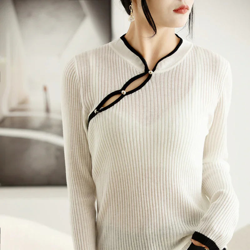 Woman wearing white ribbed knit sweater with black trim and pearl buttons on collar