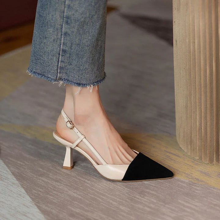 Woman wearing beige slingback heels with black pointed toe, paired with frayed hem blue jeans