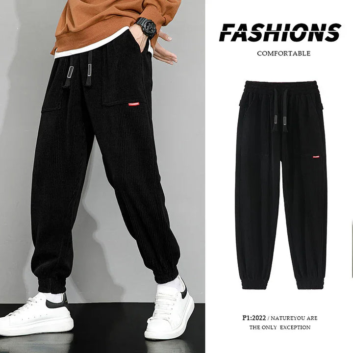 Black comfortable casual jogger pants with drawstring and elastic cuffs modeled with white sneakers