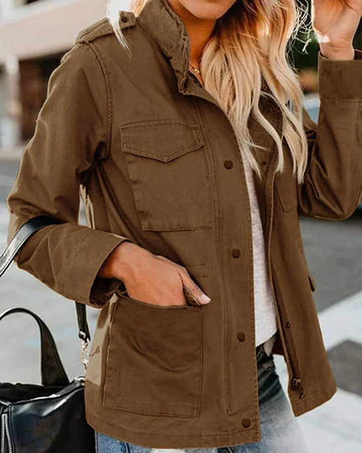 Woman wearing a brown utility jacket with flap chest pockets and large side pockets outdoors