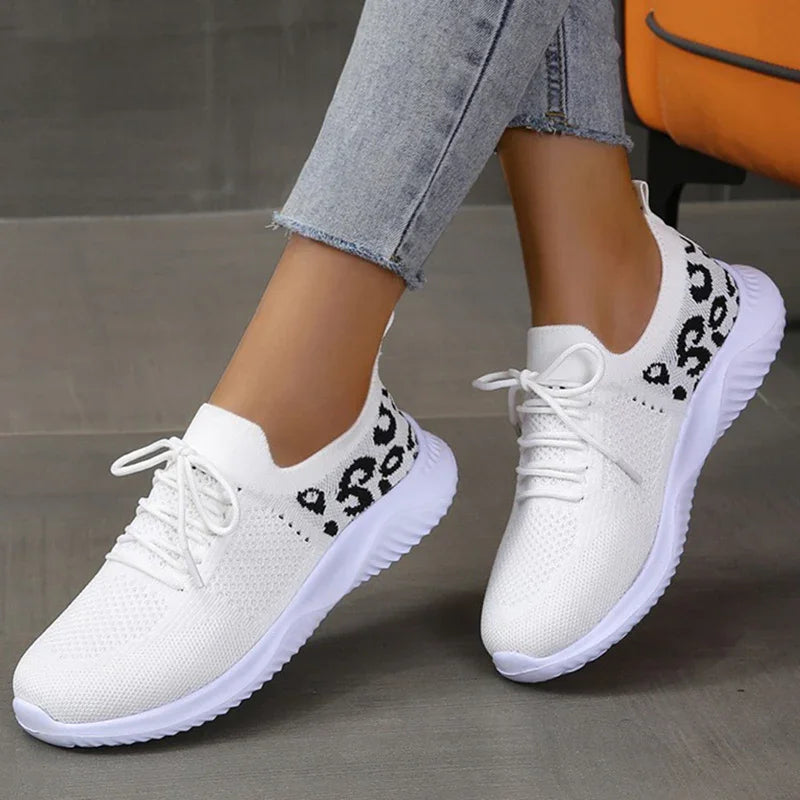 White knitted lace-up sneakers with black leopard print detail worn with light blue jeans