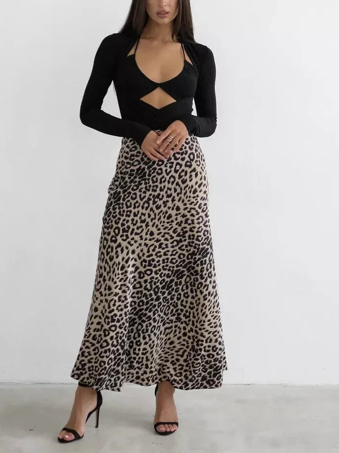Woman wearing black cutout top with long sleeves and leopard print midi skirt with black heels