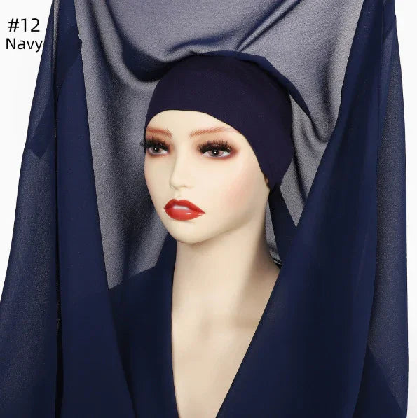 Mannequin wearing navy blue headscarf and matching fabric draped around, with realistic makeup