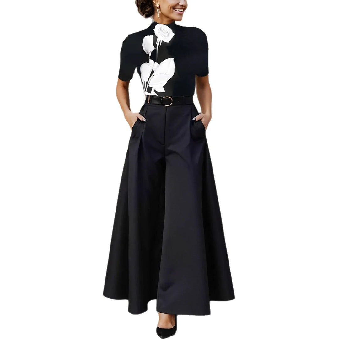 Woman wearing black wide-leg pants and black top with white rose print and belt