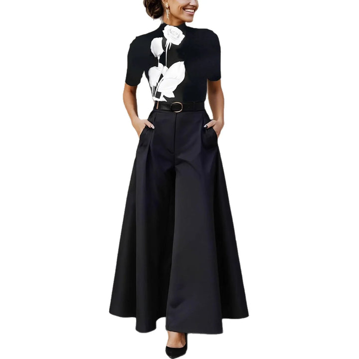 Woman wearing black wide-leg pants and black top with white rose print and belt