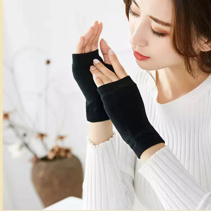 Woman wearing black fingerless gloves and a white ribbed sweater indoors