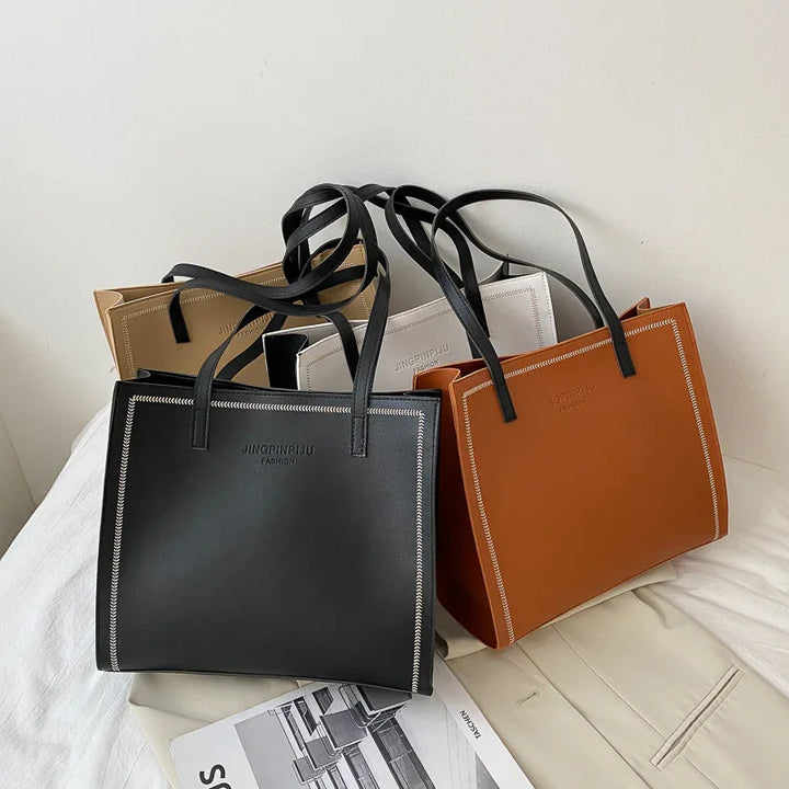 Four JINGPINPIJU FASHION tote bags in black, brown, beige, and white on a white surface
