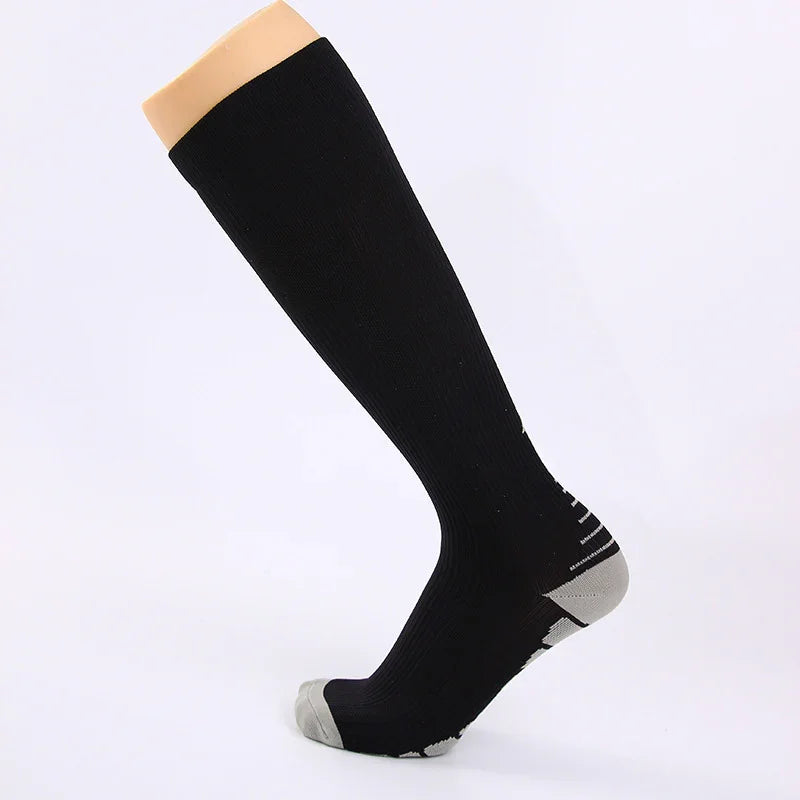 Black knee-high compression sock with gray toe and heel on mannequin foot