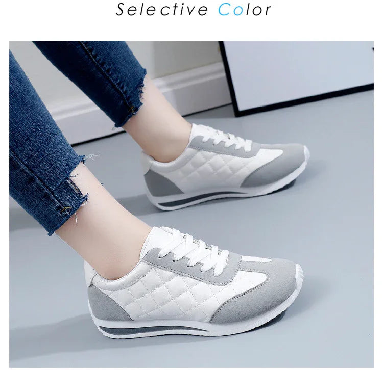 White and gray quilted sneakers with laces worn with frayed blue jeans on gray floor