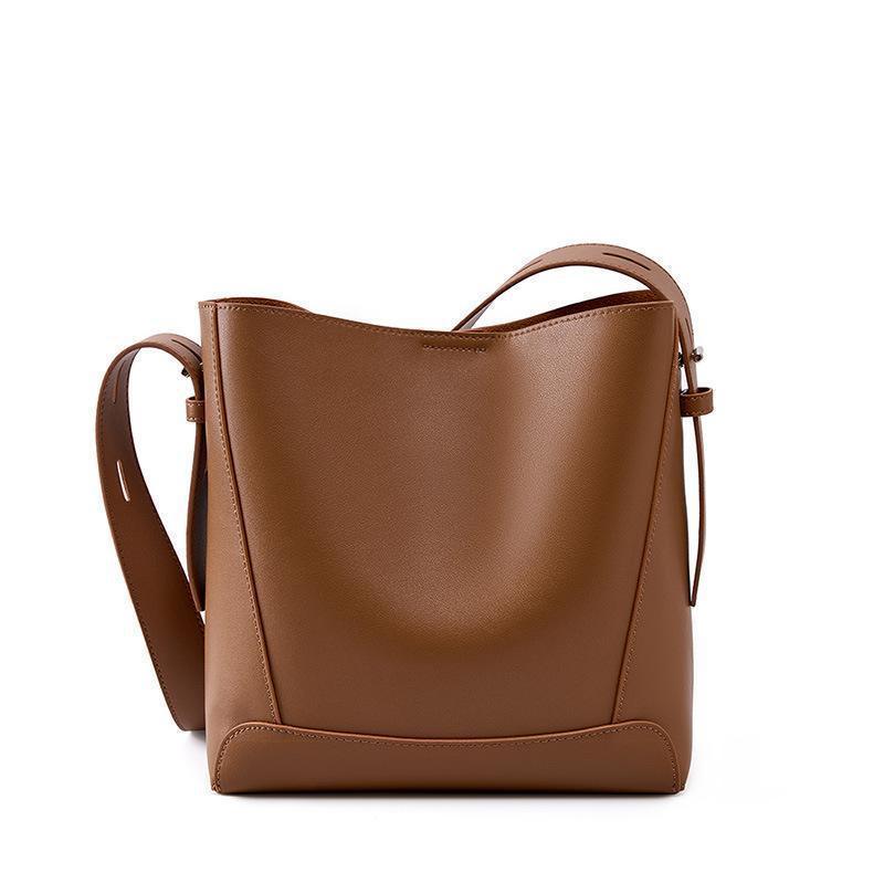 Brown leather bucket bag with adjustable shoulder strap and minimalist design