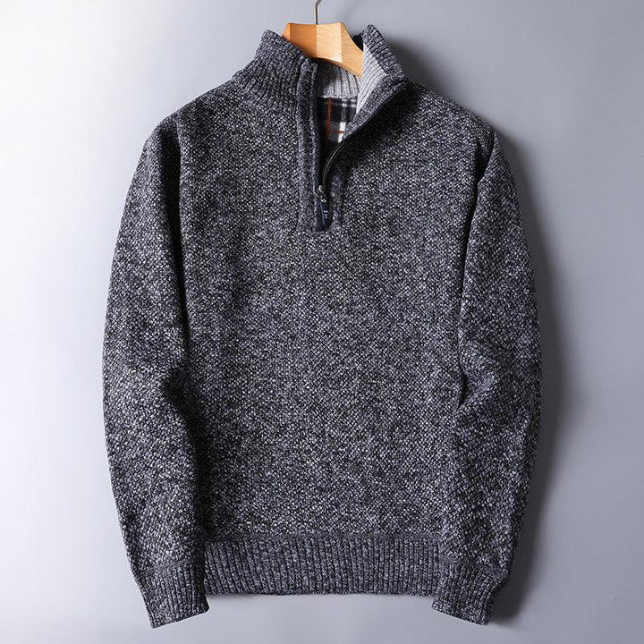 Dark gray knitted quarter-zip sweater with ribbed cuffs and plaid inner collar on wooden hanger