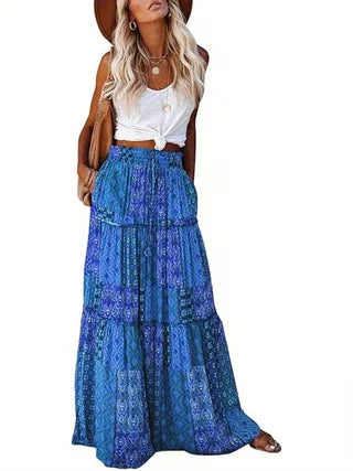 Woman wearing blue patterned boho maxi skirt with white knotted tank top and brown hat