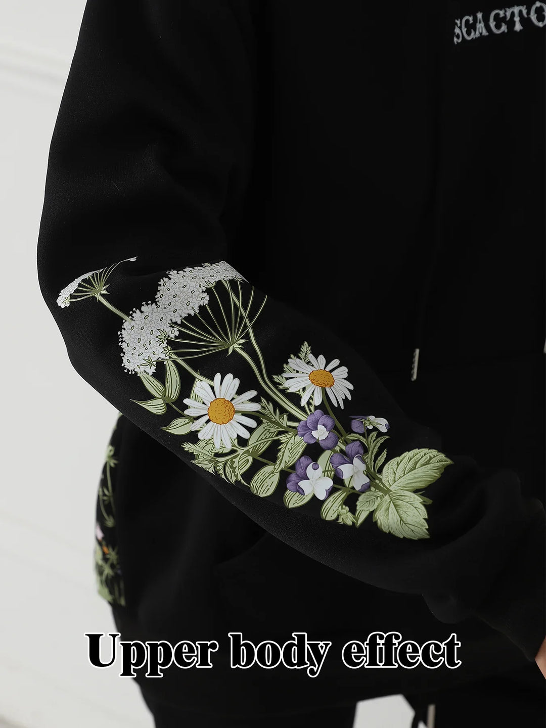 Black hoodie sleeve with detailed white daisies and purple floral embroidery