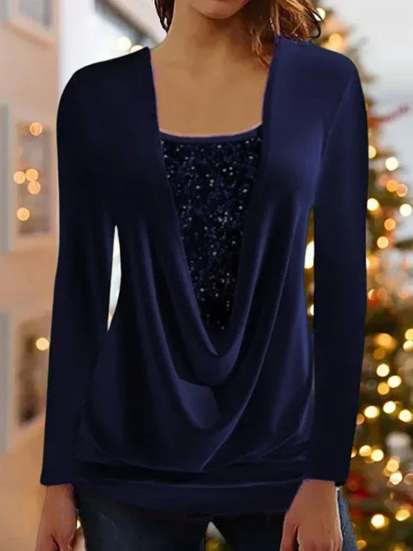 woman wearing navy blue draped blouse with sequined inner top in holiday decorated room