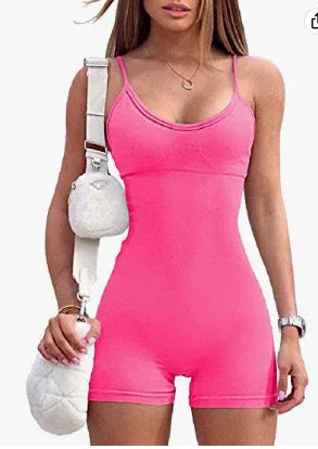 Woman wearing a bright pink sleeveless romper with a scooped neckline, carrying a white quilted crossbody bag and a matching pouch