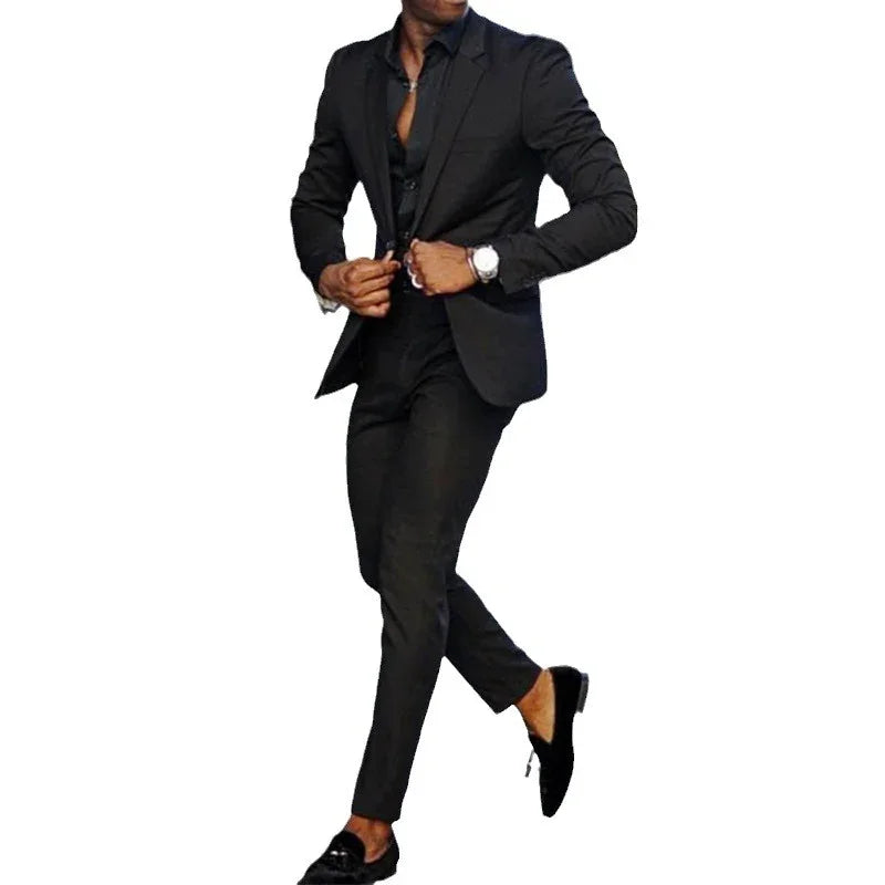 Man wearing a stylish slim-fit black suit with black loafers and a wristwatch