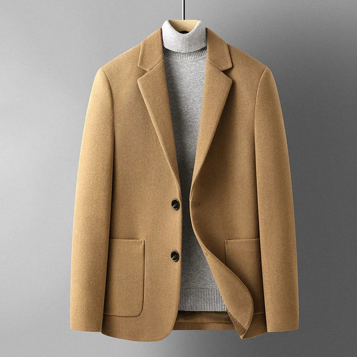 Camel brown wool blazer jacket over light gray turtleneck sweater on hanger