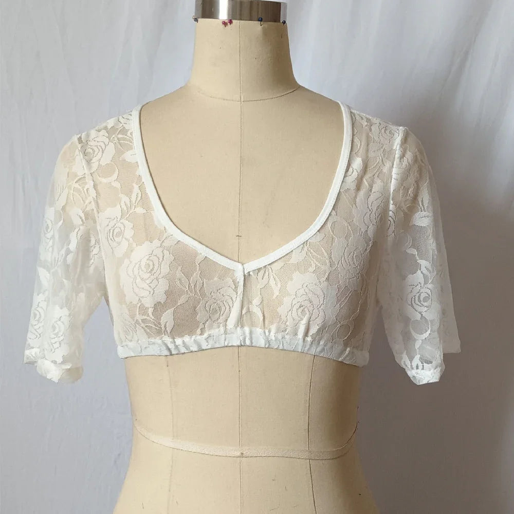 White lace crop top with floral pattern on mannequin against white background