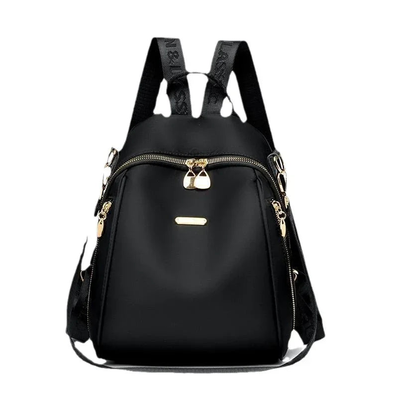 Stylish black backpack with gold zippers and adjustable straps on white background